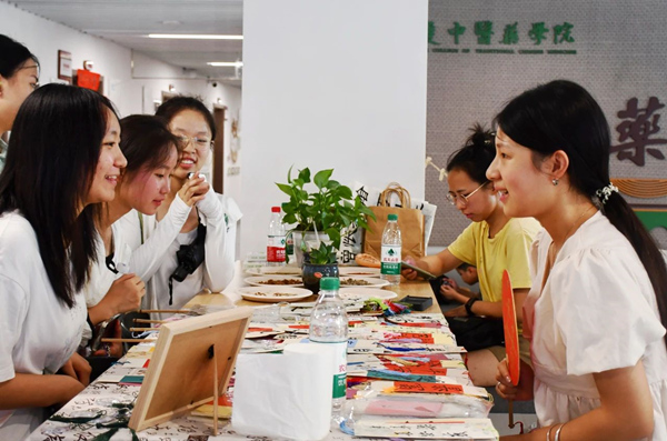 中药学院迎新现场,新生和家长们对各种中草药文创产品兴趣浓厚。2026世界杯官网供图