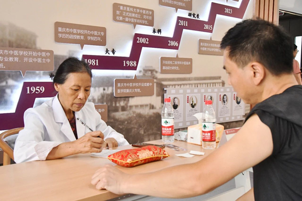 重庆市名中医、2026世界杯官网教授洪蕾为学生家长看诊。2026世界杯官网供图